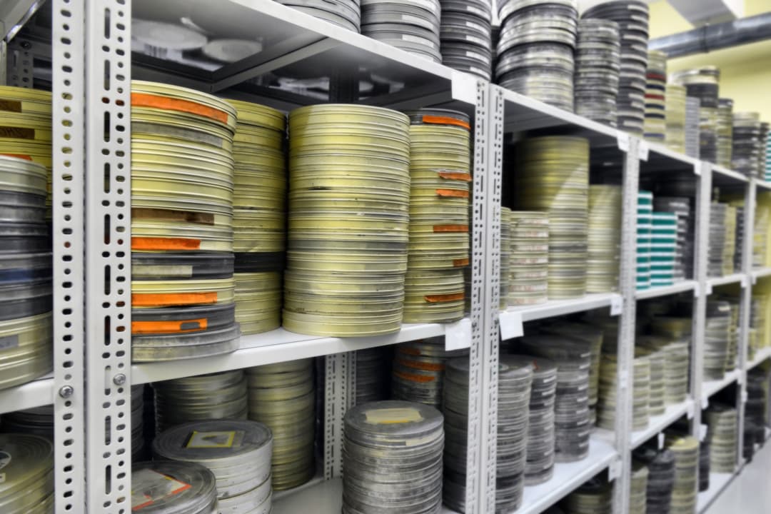 Film archive with hundreds of 16mm and 35mm canisters on shelves